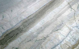 Polished stone slab with shades of gray and white, featuring a prominent dark gray vein.
