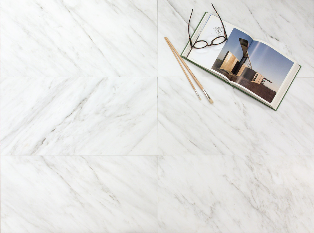 White marble tiles with subtle grey veining, featuring an open book, glasses, and pencils.