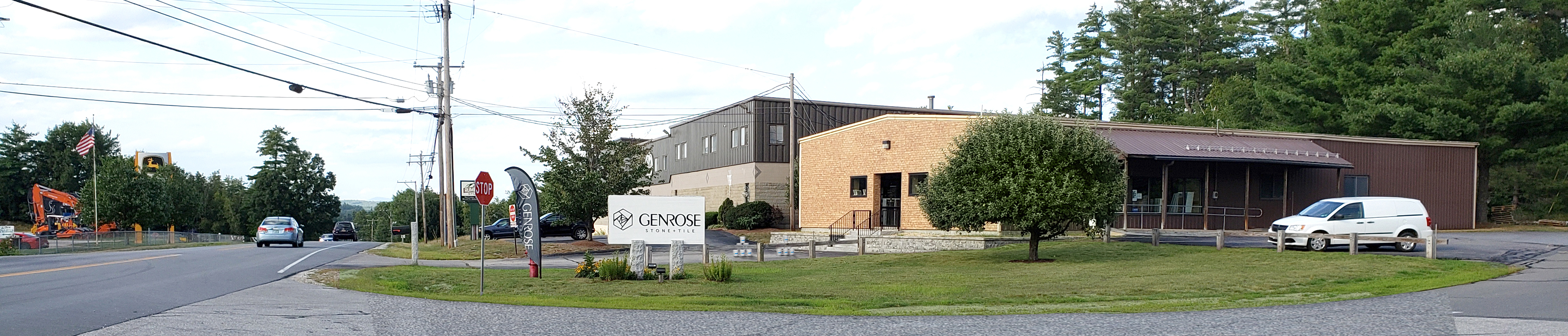 Genrose showroom with a beige and brown building, a white van, and a white sign.